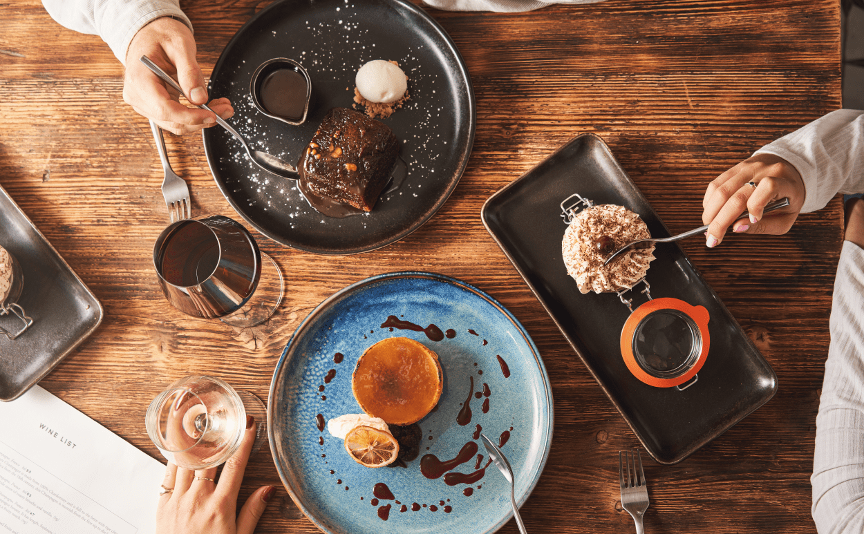 Three people tucking into desserts